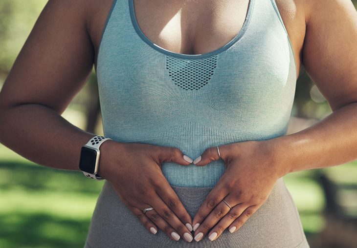 frau-bildet-herz-mit-den-haenden-auf-unterbauch-symbolisiert-lipoedem-ursache-darm